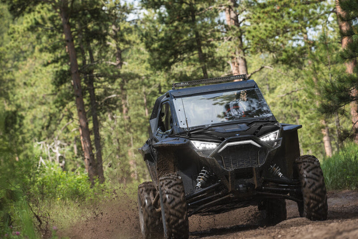 Polaris RZR Pro Xp trail riding with lightbar, roof, windshield, and doors.