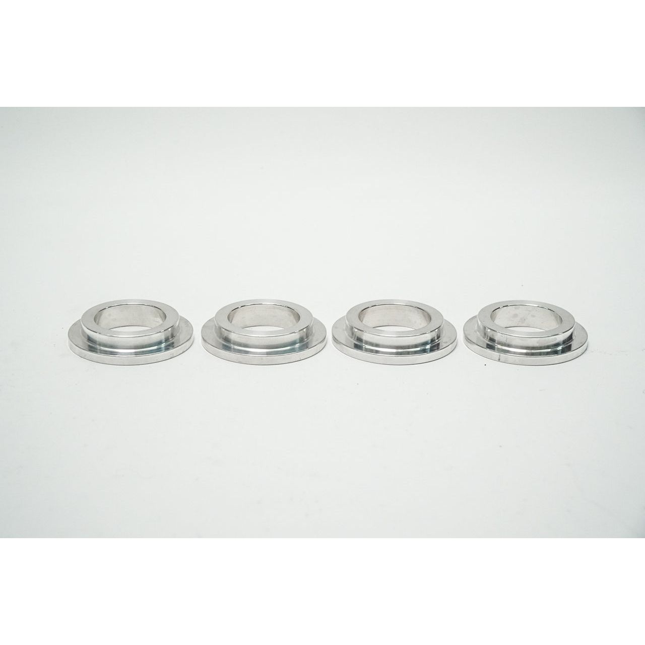 Coil spring adapters and ride height adjusters